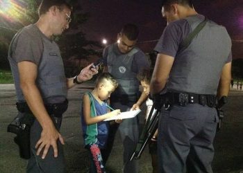 Policiais ajudam criança a fazer uma tarefa da escola