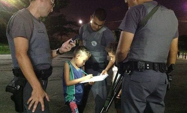 Policiais ajudam criança a fazer uma tarefa da escola
