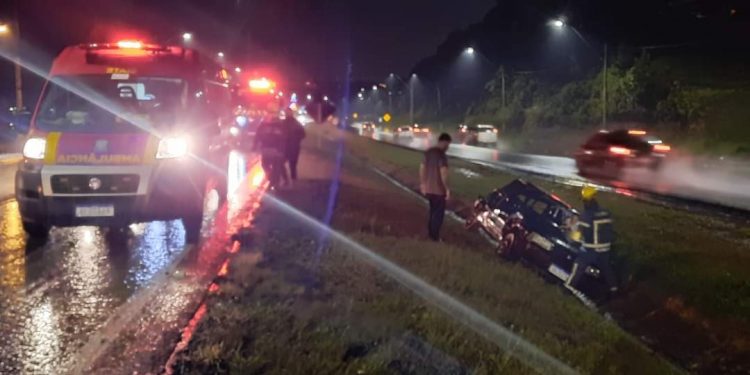 Motorista perde controle de carro com pista molhada, capota e vai parar no canteiro central da BR-277