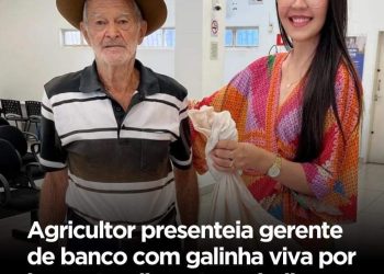 Agricultor presenteia a gerente de banco com uma galinha