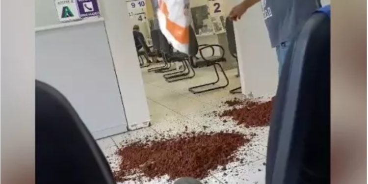 Morador despeja sacos de terra em agência da Sanepar em protesto por obra inacabada no Paraná